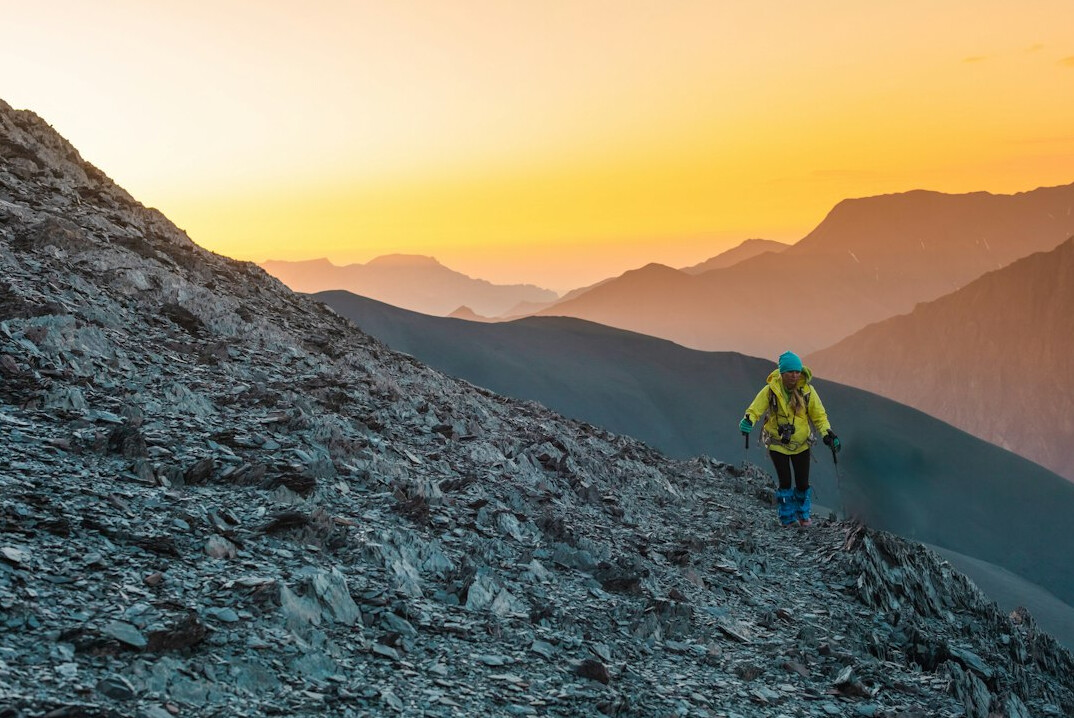 woman climbing mountain at dawn